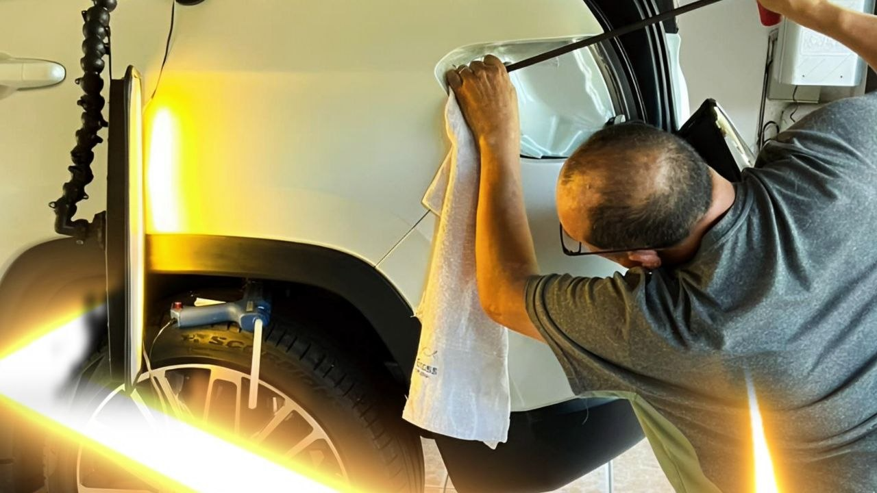 Profissional de martelinho de ouro reparando amassado na lataria de um carro
